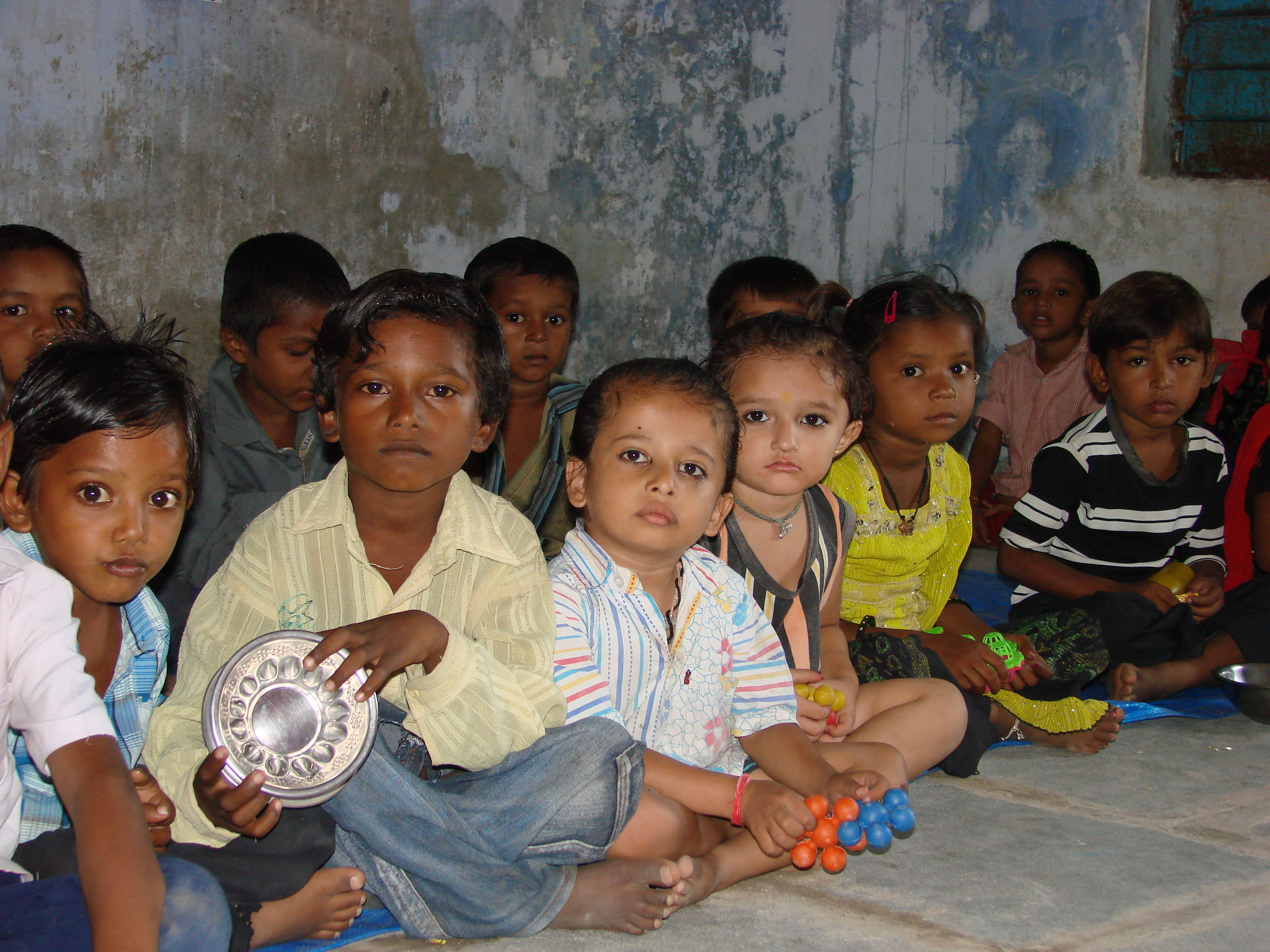 Barefoot children sitting on the floor of their classroom at a school in India Barefoot children sitting on the floor of their classroom at a school in India