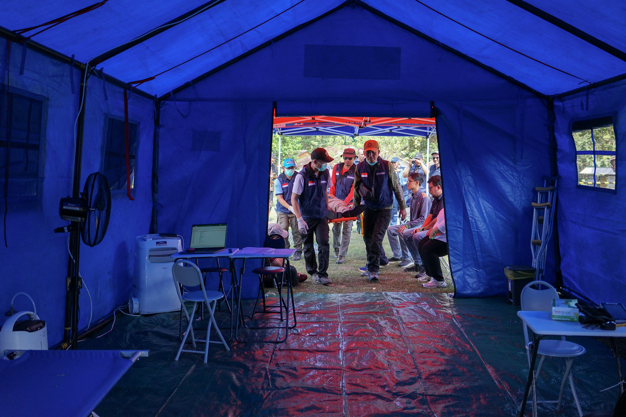 DSC06828-2 Interior of blue emergency tent with medical equipment, rescue team members gathered at entrance