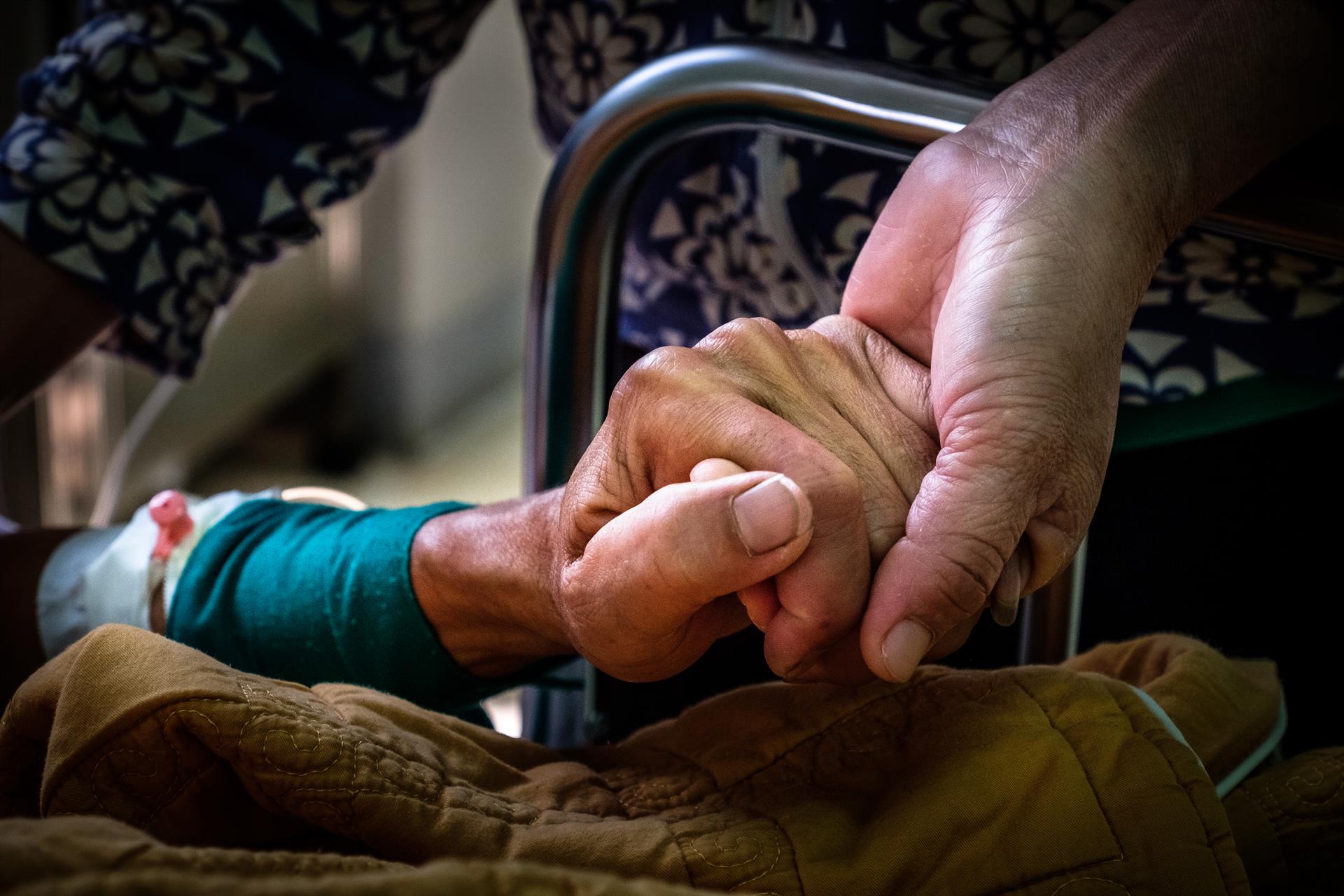 Tuberculosis 3 A patient and loved one hold hands.