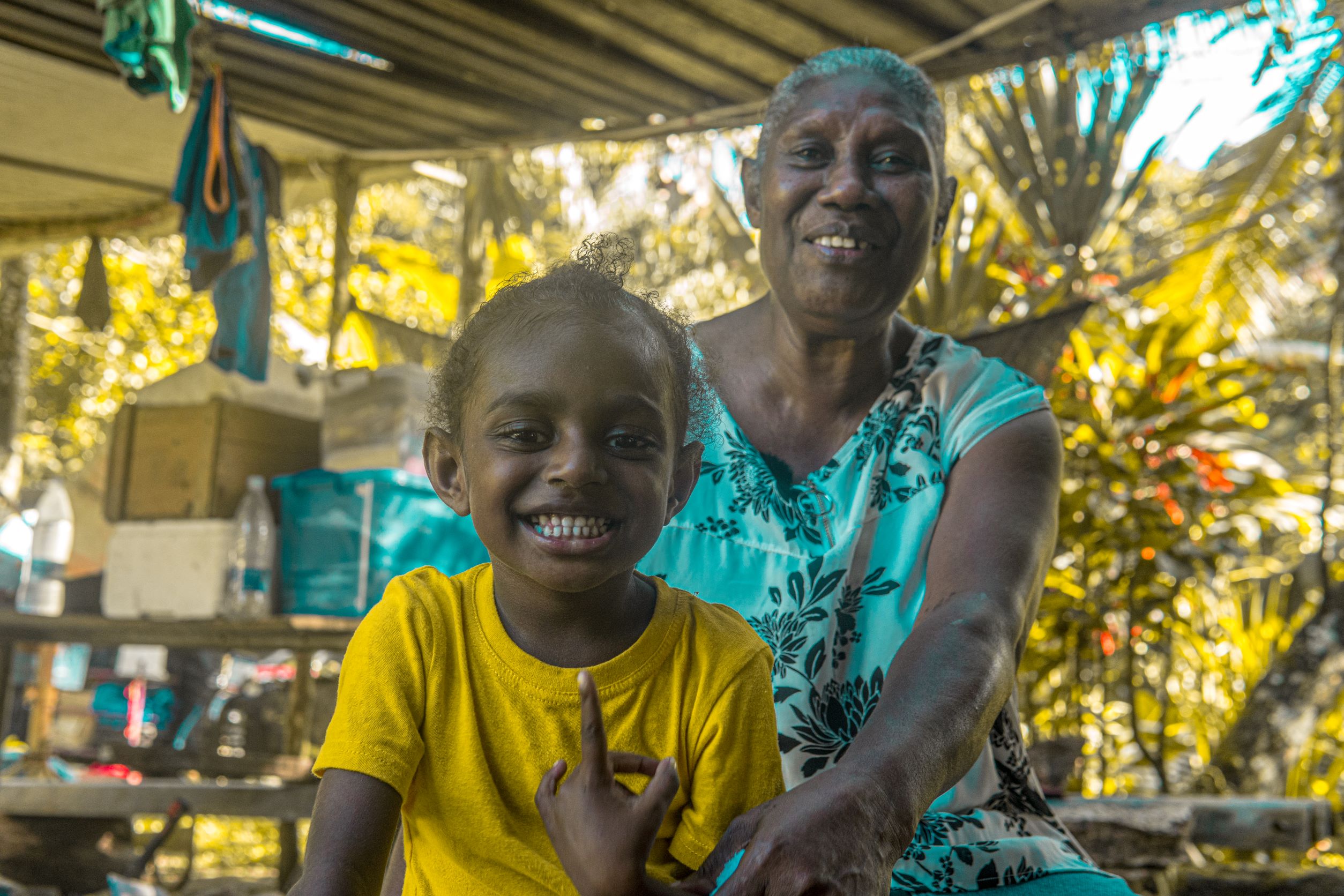 EmilyVanuatu3 A young girl in Vanuatu smiles to show her teeth with her grandmother